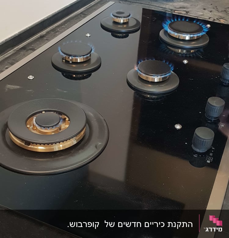 כיריים גז עם להבות וכלי עבודה על השיש